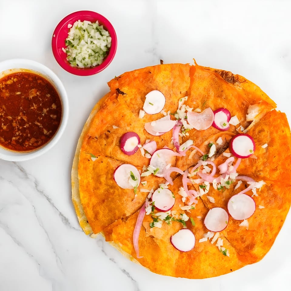 MissTakoz birria pizza with radishes, onions, and cilantro, served with a side of consommé and diced onions.